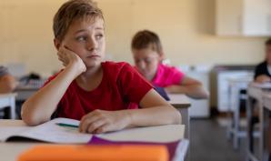 Un garçon devant son cahier en classe