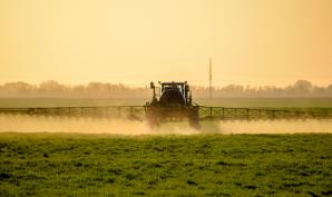 tracteur qui arrose de produits chimiques une terre agricole
