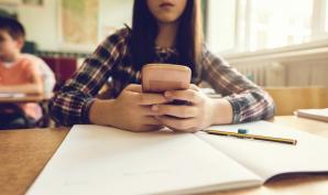 une jeune en classe avec son portable